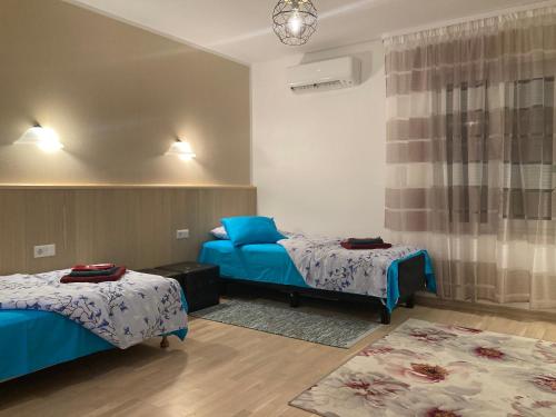 a room with two beds with blue sheets and a rug at Renthouse Guest Apartment in Paide