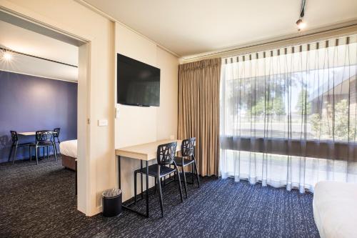 a hotel room with a desk and a bed and a window at Nightcap at Gateway Hotel in Corio