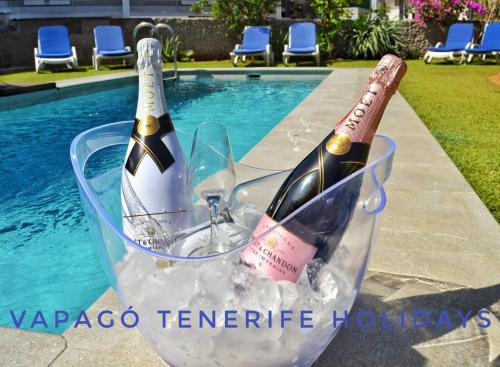 dos botellas de champán en un cubo de hielo junto a una piscina en Deluxe Villa with private pool El Duque, en Adeje