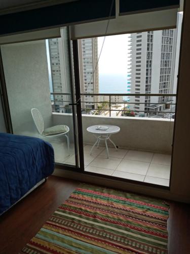 una camera da letto con balcone affacciato sull'oceano di Zafiro Reñaca a Viña del Mar