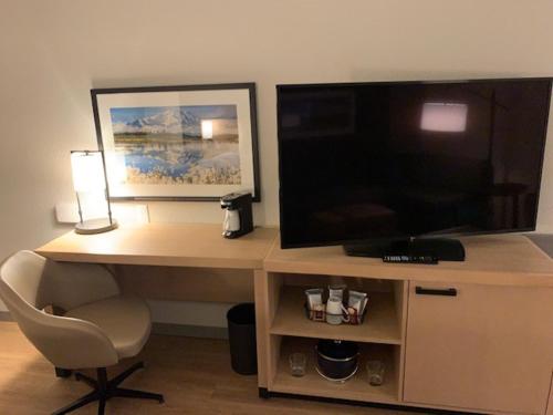 a desk with a television and a chair in a room at Hyatt Place Fairbanks in Fairbanks