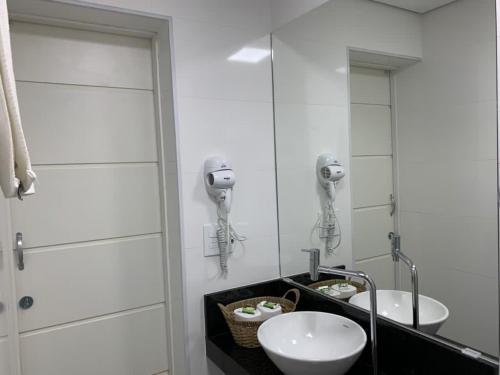 Baño con 2 lavabos y espejo en Apart-Hotel Cavalinho Branco (311 e 409 ), en Águas de Lindóia