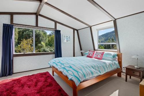 sypialnia z łóżkiem i dużym oknem w obiekcie Pukenui Paradise - Havelock Holiday Home w mieście Havelock