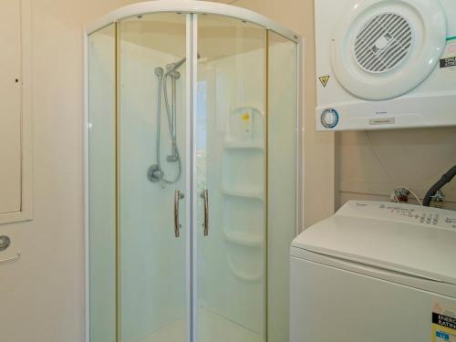 La salle de bains est pourvue d'une douche avec une porte en verre. dans l'établissement Treetop Bach - Hahei Bach, à Hahei