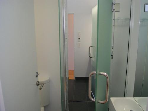 a bathroom with a glass shower and a toilet at Bauhaus - Kaiteriteri Holiday Home in Kaiteriteri