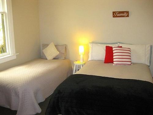 a bedroom with two beds and a lamp on a table at The Ski House on Miharo - Rangataua Holiday Home in Ohakune