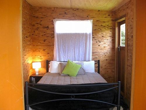 a small bedroom with a bed with a window at The Ski House on Miharo - Rangataua Holiday Home in Ohakune