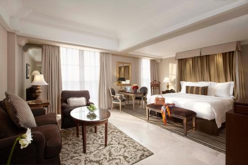 a hotel room with a bed and a living room at Hotel Gran Mahakam in Jakarta