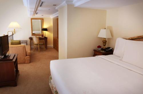 a hotel room with a bed and a living room at Hotel Gran Mahakam in Jakarta