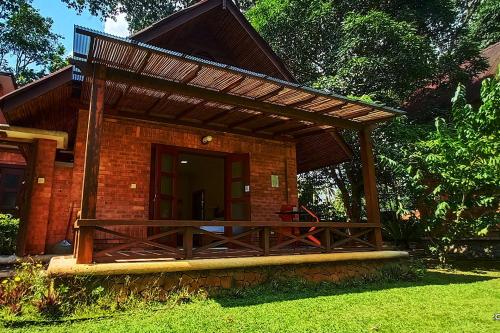 a brick house with a wooden porch with a roof at Tanjung Inn in Kuantan