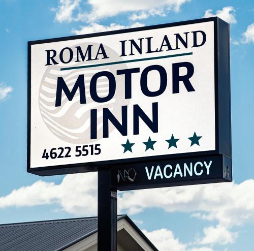 
a sign on a pole in front of a building at Roma Inland Motor Inn in Roma
