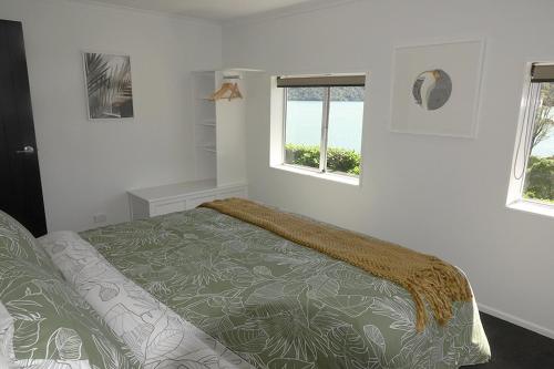 een slaapkamer met een bed en 2 ramen bij Bora Castle. in Havelock