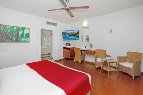 a bedroom with a bed and a table and chairs at Ramada By Wyndham Cairns City Centre in Cairns