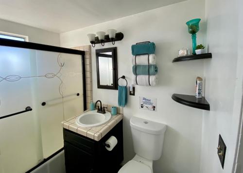 a bathroom with a toilet and a sink and a mirror at Center Street Villas in Joshua Tree