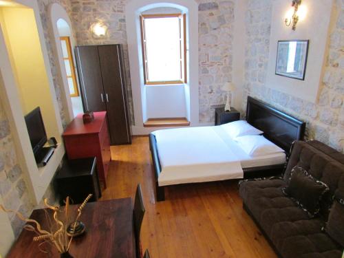a bedroom with a bed and a couch at Apartments Popovic in Kotor