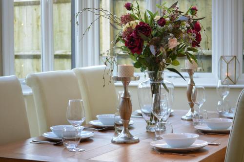 une table en bois avec un vase de fleurs. dans l'établissement Darly Cottage, à Bourton-on-the-Water