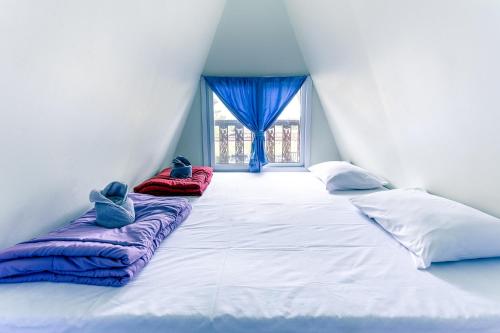 Cette chambre dispose d'un grand lit avec deux oreillers et d'une fenêtre. dans l'établissement Baan Sin Suk, à Chiang Rai