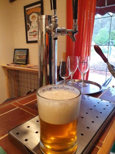 a glass of beer sitting on top of a bar at Oaktree Guest House in Narbethong