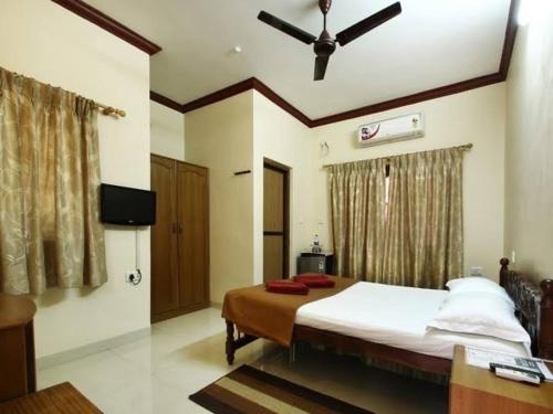 a bedroom with a bed and a ceiling fan at Henry's Place in Calangute