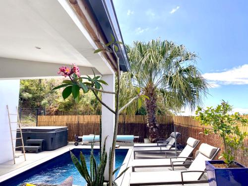 a patio with chairs and a swimming pool at Chambres d'hôtes CASA COSY in Les Avirons