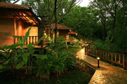 a garden with a house with a fence and lights at Palau Pacific Resort in Koror