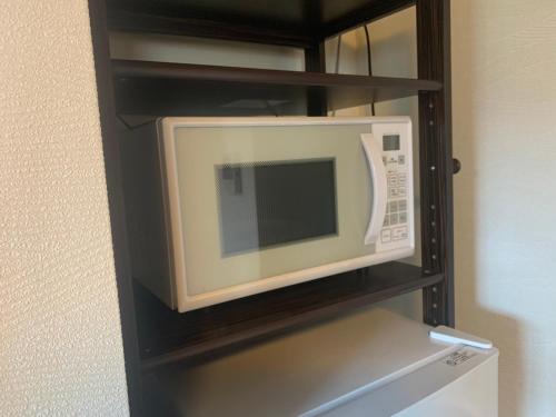 a microwave oven sitting on top of a refrigerator at B&B YUIGAHAMA in Kamakura