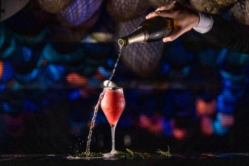a person pouring a drink from a bottle into a glass at Kempinski Hotel Hangzhou in Hangzhou