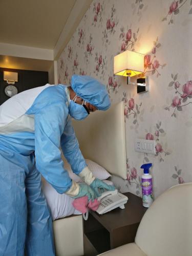 a person in a hotel room preparing a bed at Honeymoon Inn Mussoorie in Mussoorie