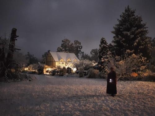 a person standing in front of a house at night at Oaktree Guest House in Narbethong