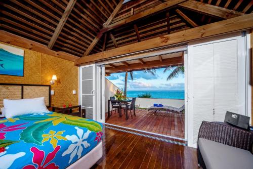 a bedroom with a bed and a view of the ocean at Palm Grove in Rarotonga