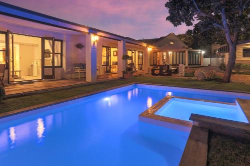 a swimming pool with blue lights in a backyard at Sixteen Guesthouse on Main in Hermanus