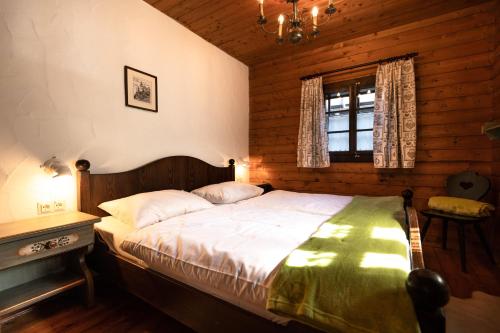ヘルマゴルにあるApartment HERZALE - Nassfeldの木製の部屋に大型ベッドが備わるベッドルーム1室が備わります。