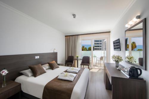 een hotelkamer met een bed en een bureau bij Kapetanios Limassol Hotel in Limassol
