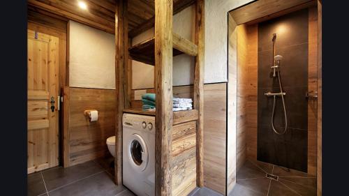 ein Bad mit einer Waschmaschine und einer Dusche in der Unterkunft Apartment Wagrainblick in Wagrain