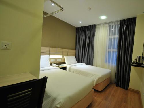سرير أو أسرّة في غرفة في U Design Hotel Temerloh