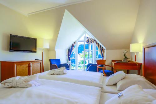 a hotel room with two beds and a television at Balmer See – Hotel•Golf•Spa in Balm