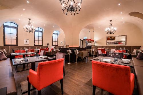 a dining room with tables and chairs and chandeliers at Deidesheimer Hof in Deidesheim