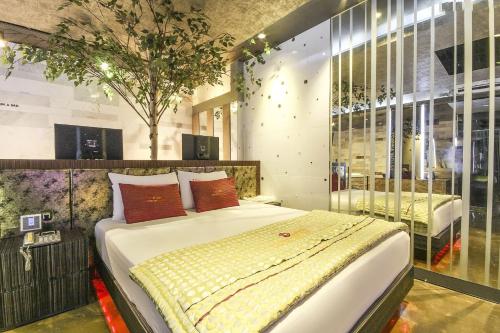 Login Hotel في دايغو: غرفة نوم فيها سرير وشجرة