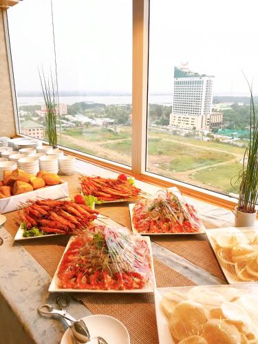 a buffet with several plates of food on a table at Holiday One Can Tho Hotel in Can Tho