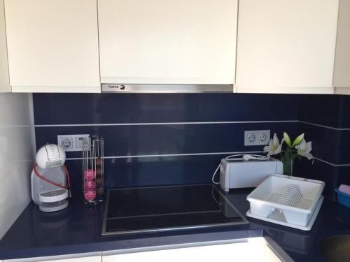 a kitchen with white cabinets and a black counter top at Apartamentos Marjal 3 in Guardamar del Segura