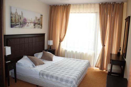 Un dormitorio con una cama y una ventana grande. en Spider House Aparthotel, en Pamporovo