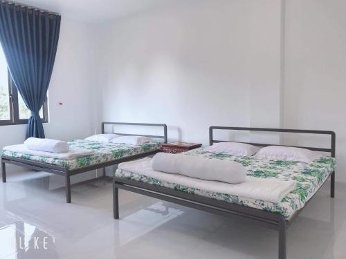 two beds sitting in a room at Minh Kim Guesthouse in Ấp Phó
