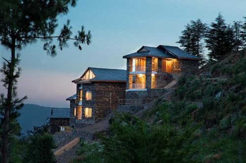 a house on a hill with its lights on at StayVista at DAAFI House with Comp Breakfast in Theog