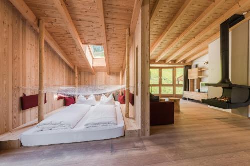 a bedroom in a wooden house with two beds at Naturhotel Rainer in Racines