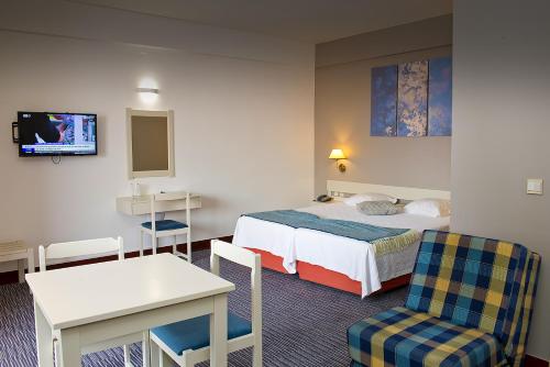 um quarto de hotel com uma cama, uma mesa e cadeiras em Aparthotel Imperatriz no Funchal