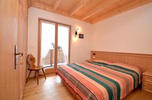 una camera da letto con un letto e una finestra di Aurturist Dobbiaco Roulette a Dobbiaco