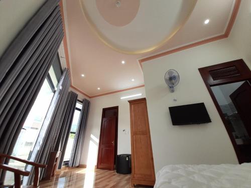 a bedroom with a bed and a tv on the wall at Khách sạn Nguyên Long in Bao Loc