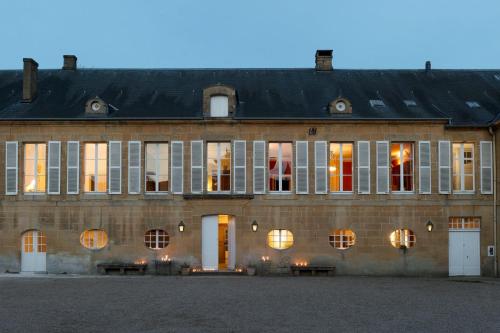 a large brick building with windows and a black roof at Château de Martigny 