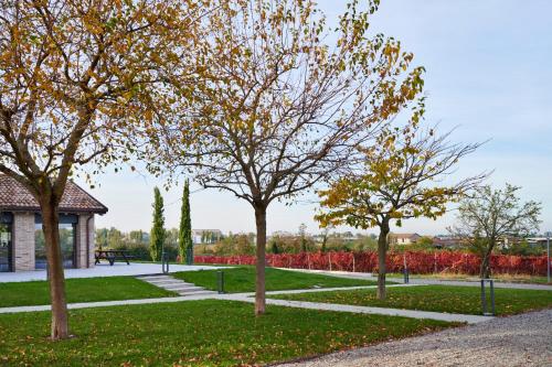 a group of trees in a park with a building at Agriturismo La Razza in Reggio Emilia