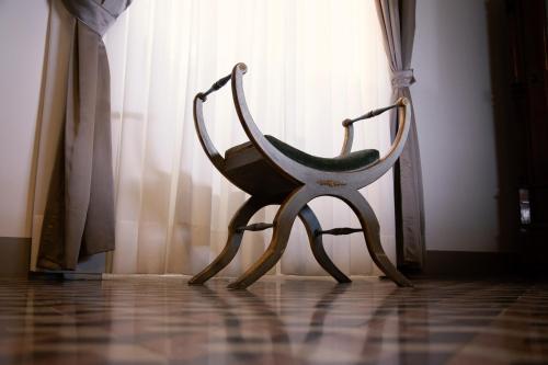 a wooden chair sitting in front of a window at Villa Giordanelli in Scalea